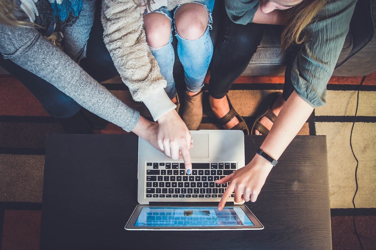 millennials pointing to a macbook air