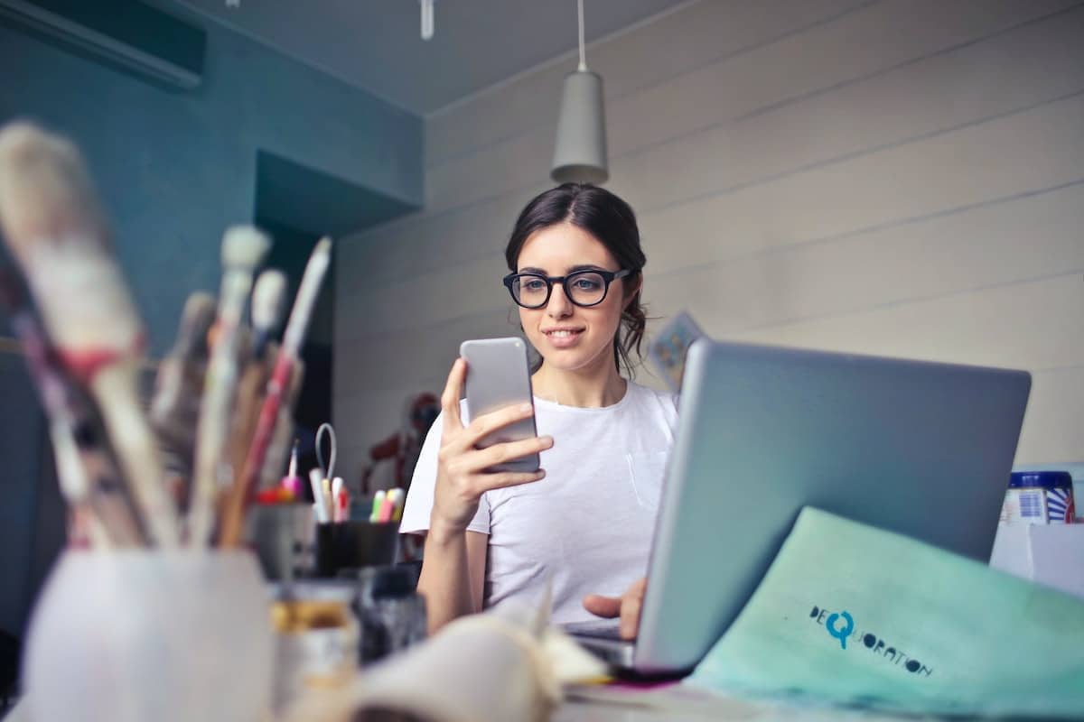 woman looking her phone at her desk