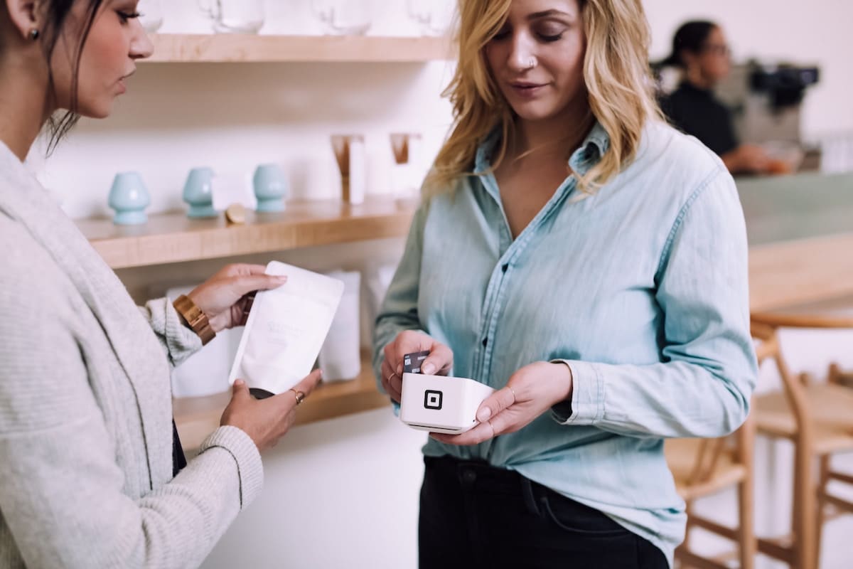 woman paying with a debit card at a store that is overdrafting her debit card