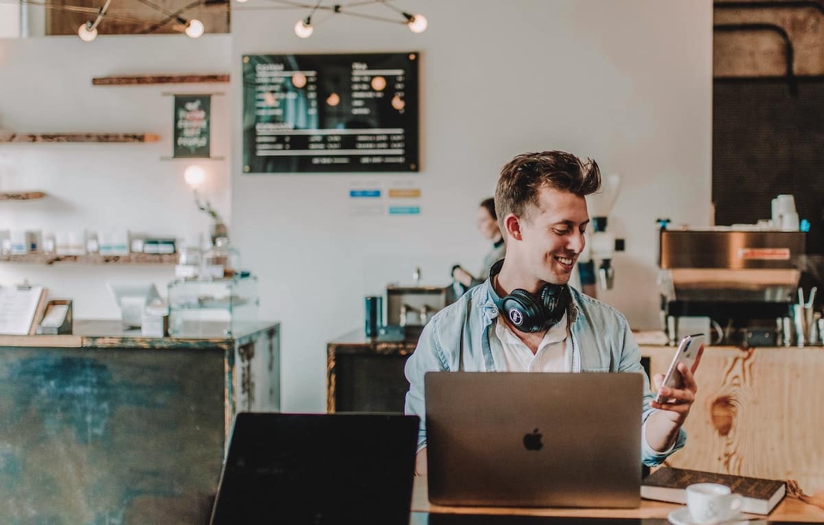 man looking on her phone at a coffee shop