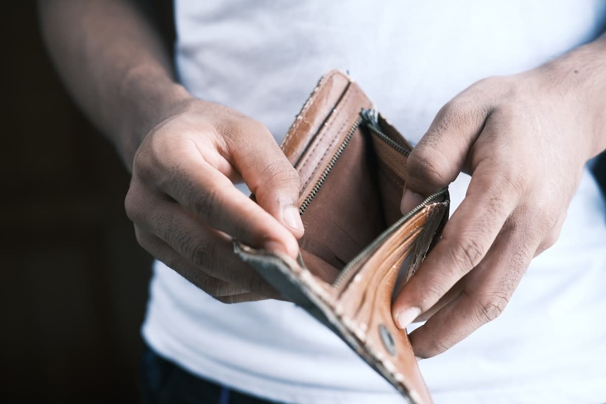 man opening wallet with nothing in it